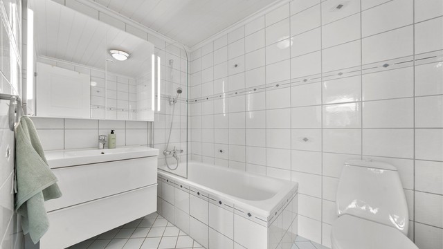 Flislagt badekar med glassfelt. Vegghengt speilskap med innebygd lys. TG3 etter helhetsvurdering.