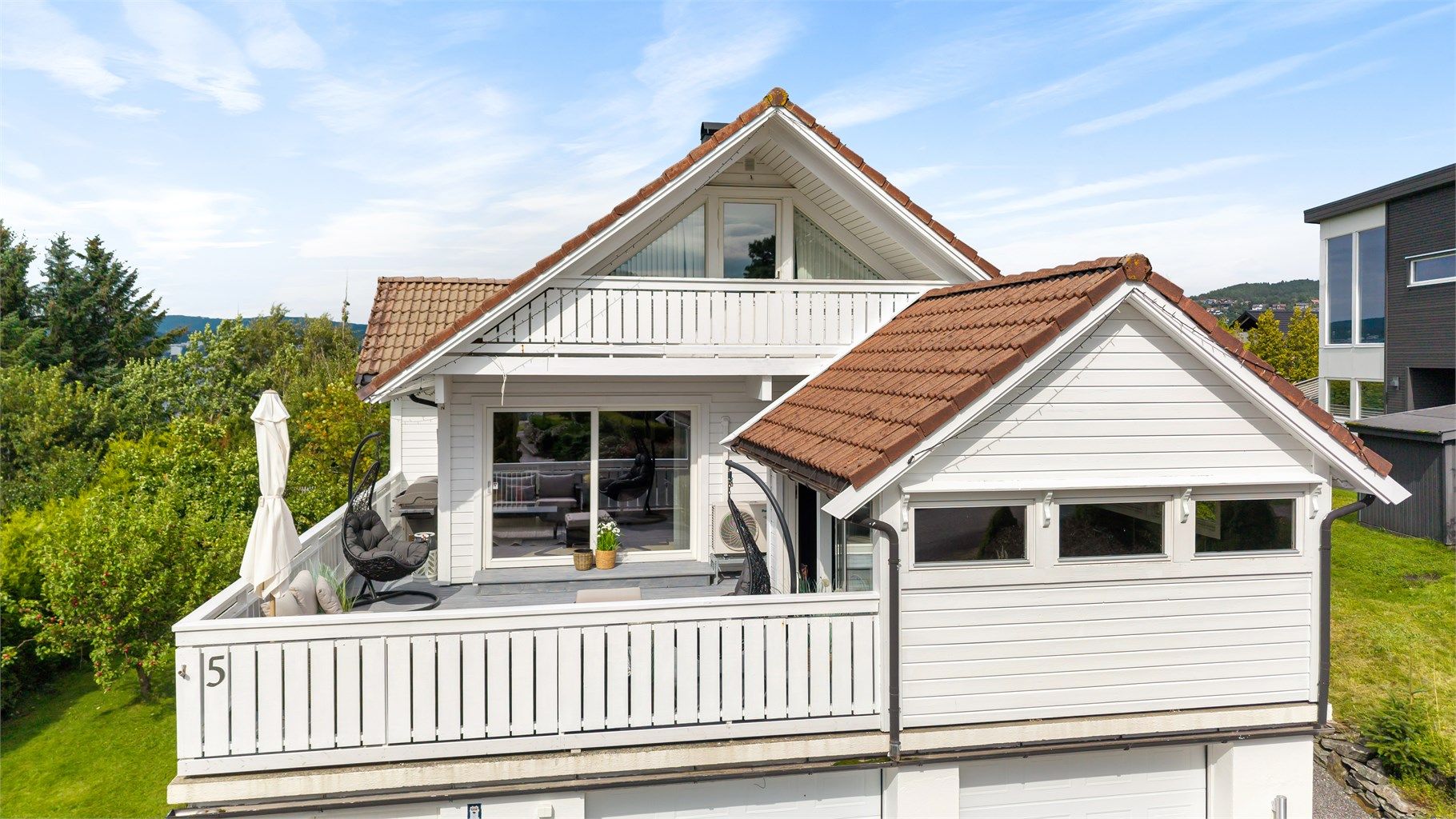 Boligen har en klassisk arkitektur med saltak og liggende trekledning.