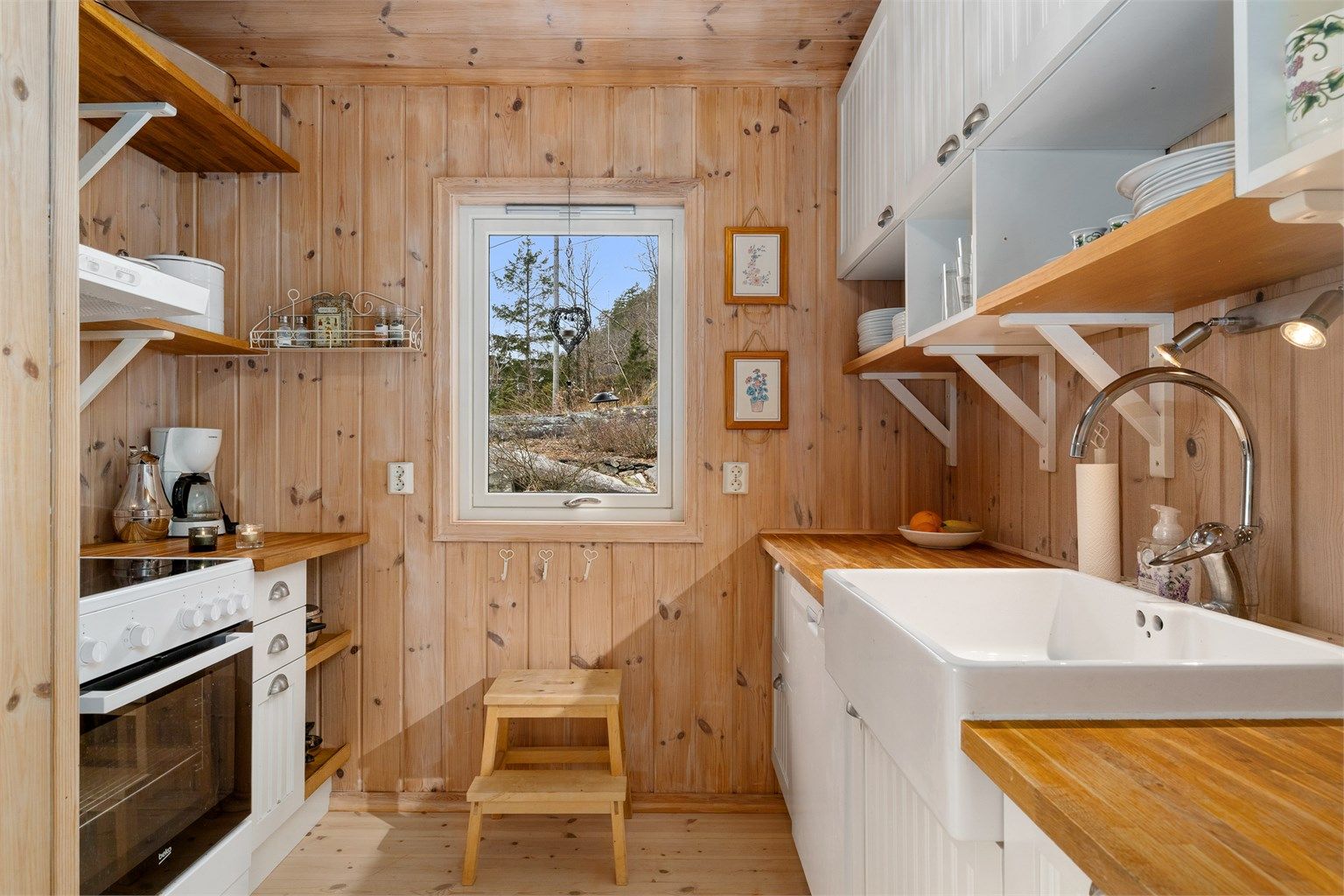 Kjøkkeninnredningen i den nye delen rommer stor porselensvask og kokesone på motstående side.