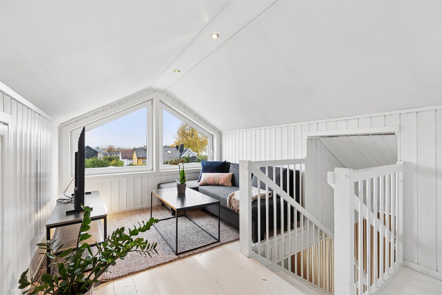 Loftstuen har gavlvinduer med utsyn over nærområdet og luke til knevegg.