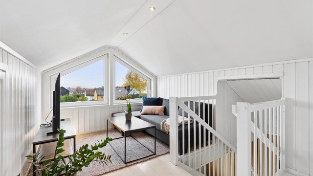 Loftstuen har gavlvinduer med utsyn over nærområdet og luke til knevegg.
