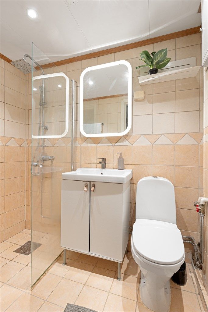 Flislagt baderom med regnfallsdusj og downlights i himling
