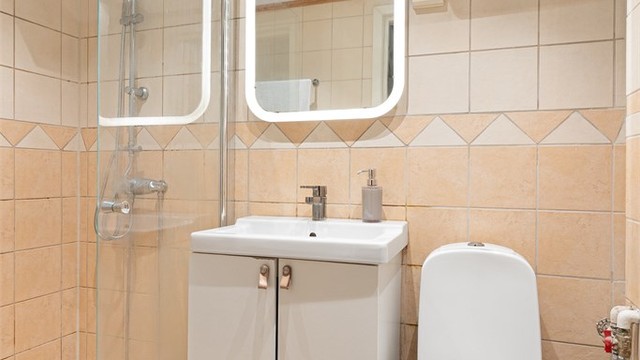 Flislagt baderom med regnfallsdusj og downlights i himling