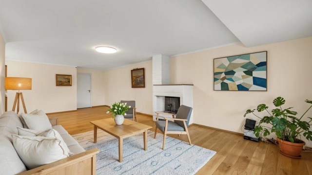 Stuen er romslig og møbleringsvennlig og med en hyggelig peis som varmer opp og skaper hygge på kjøligere dager. Digitalt stylet bilde.
