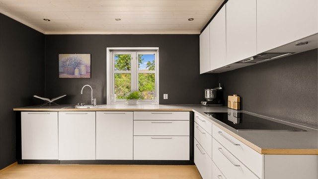 Kjøkken med stramt design og integrerte hvitevarer.