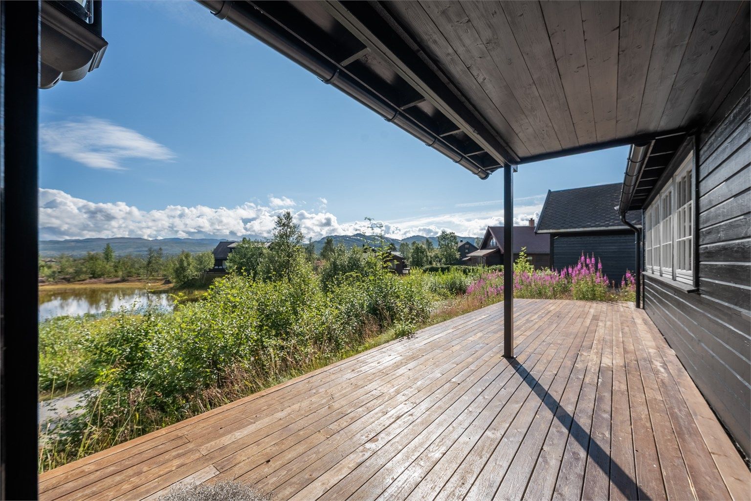 Solrik terrasse med god plass til utemøbler og hyggelige dager og kvelder langs hytteveggen.
