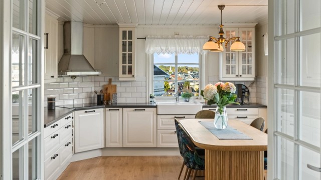 Innredningen har profilerte fronter og benkeplater av laminat. Fliser på vegg mellom benkeplate og overskap. Det er rikelig med skap og skuffer.