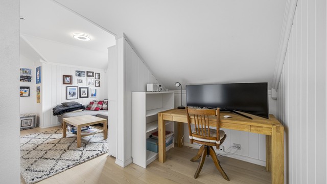 En del av loftstuen er innredet med en praktisk arbeidsplass/kontor.
