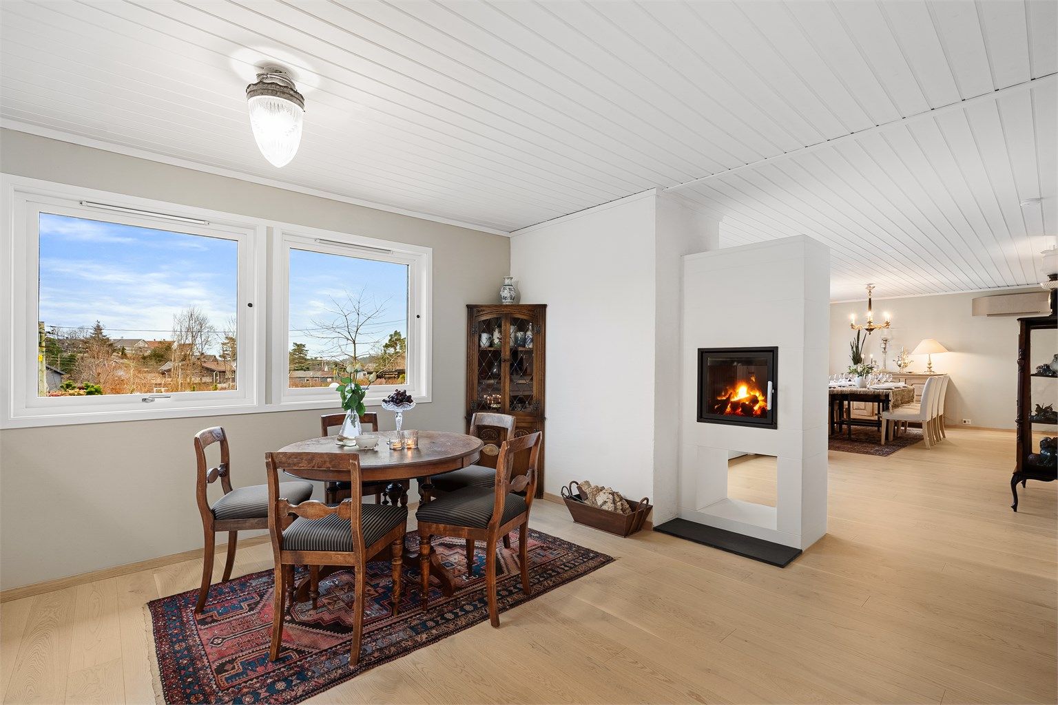 Peisen er et smykke i rommet og en naturlig sonedeler til resten av stuen/spisestuen. 