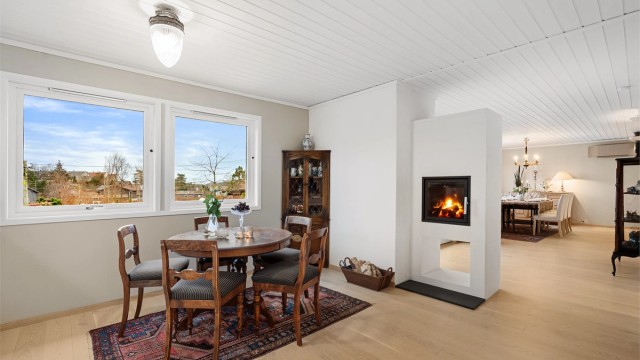 Peisen er et smykke i rommet og en naturlig sonedeler til resten av stuen/spisestuen.