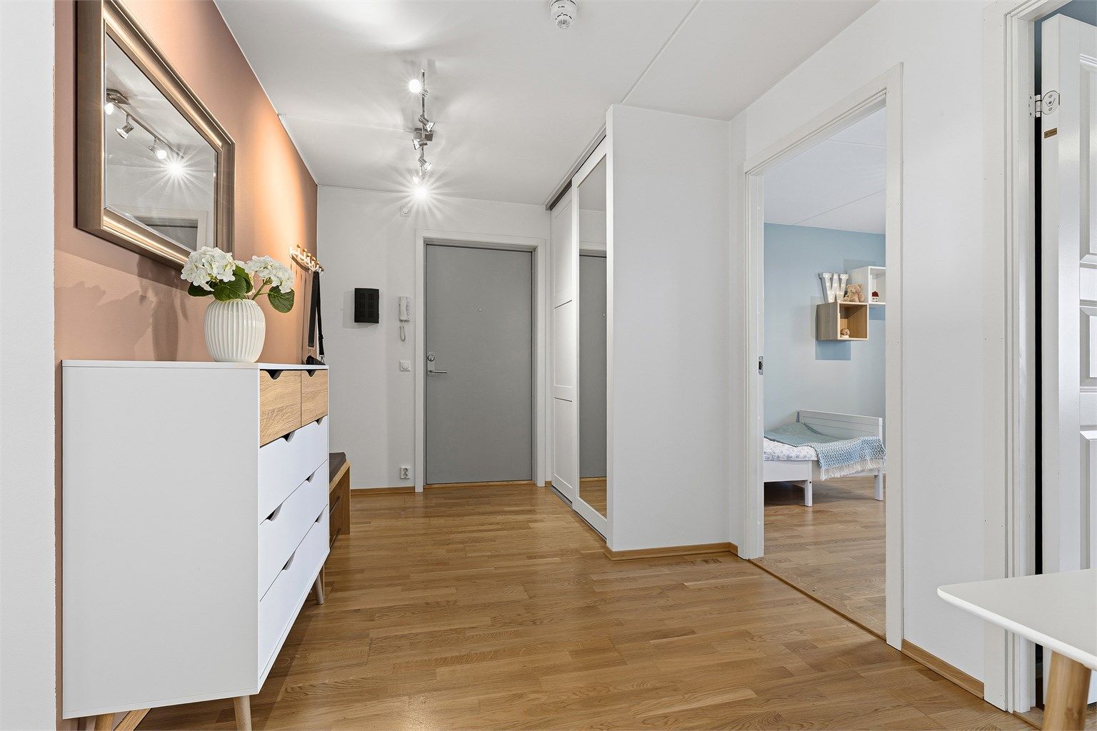 Praktisk skyvedørsgarderobe med speilfronter gir rikelig med oppbevaringsplass for yttertøy.