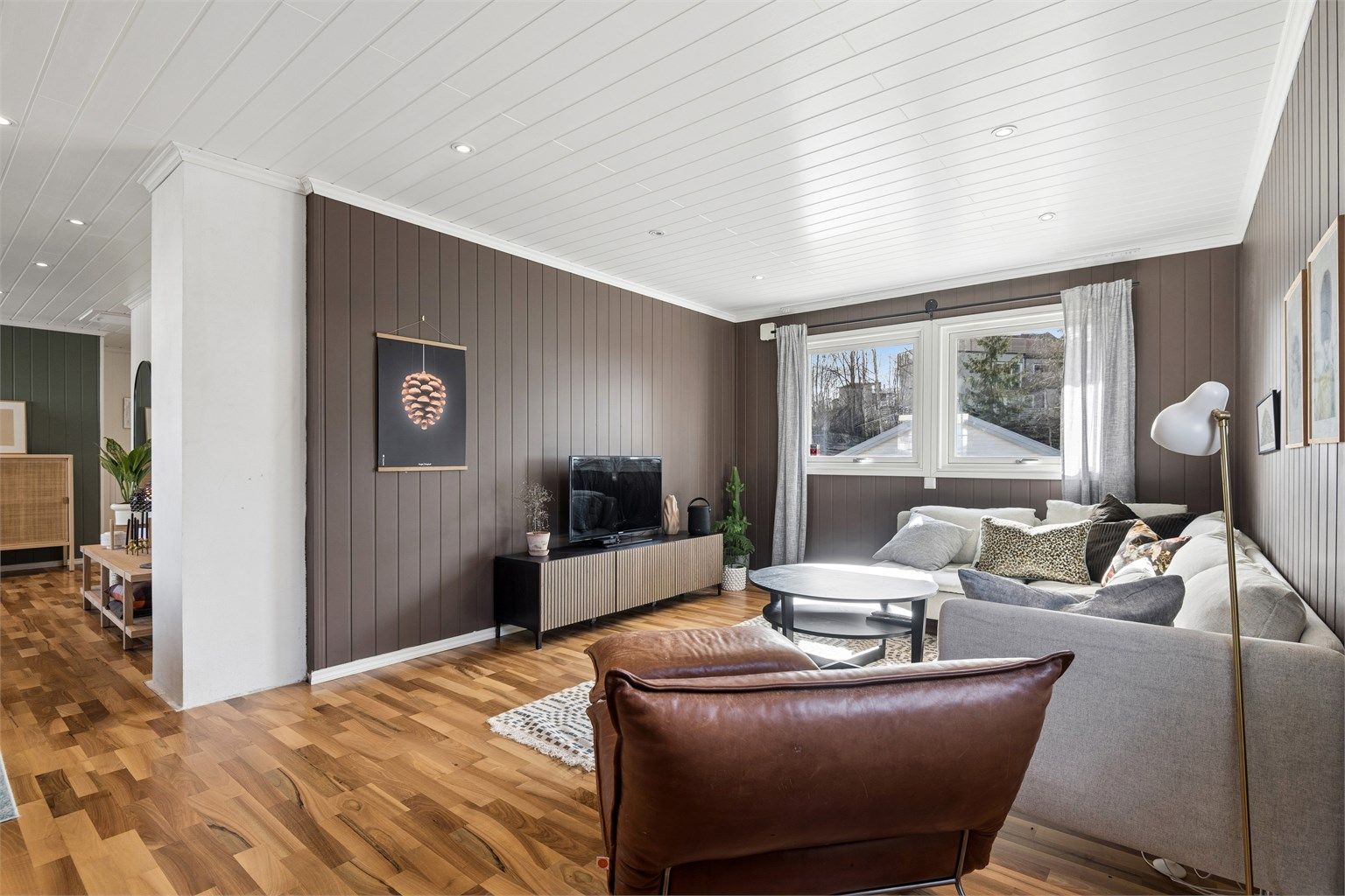 Stuen er romslig og har god plass til både sofagruppe og spiseplass. Rommet oppleves lyst og trivelig, og store vindusflater slipper inn godt med dagslys. (Foto: EFKT v/Jonas Hasselgren)