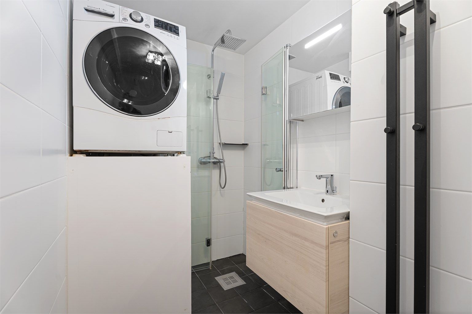 Badet er flislagt og har dusjnisje med innfellbare dører, regndusj, servant med skuffer samt overskap med lagringsplass. Det er også plass til vaskemaskin og varmtvannsberederen er plassbygd. 