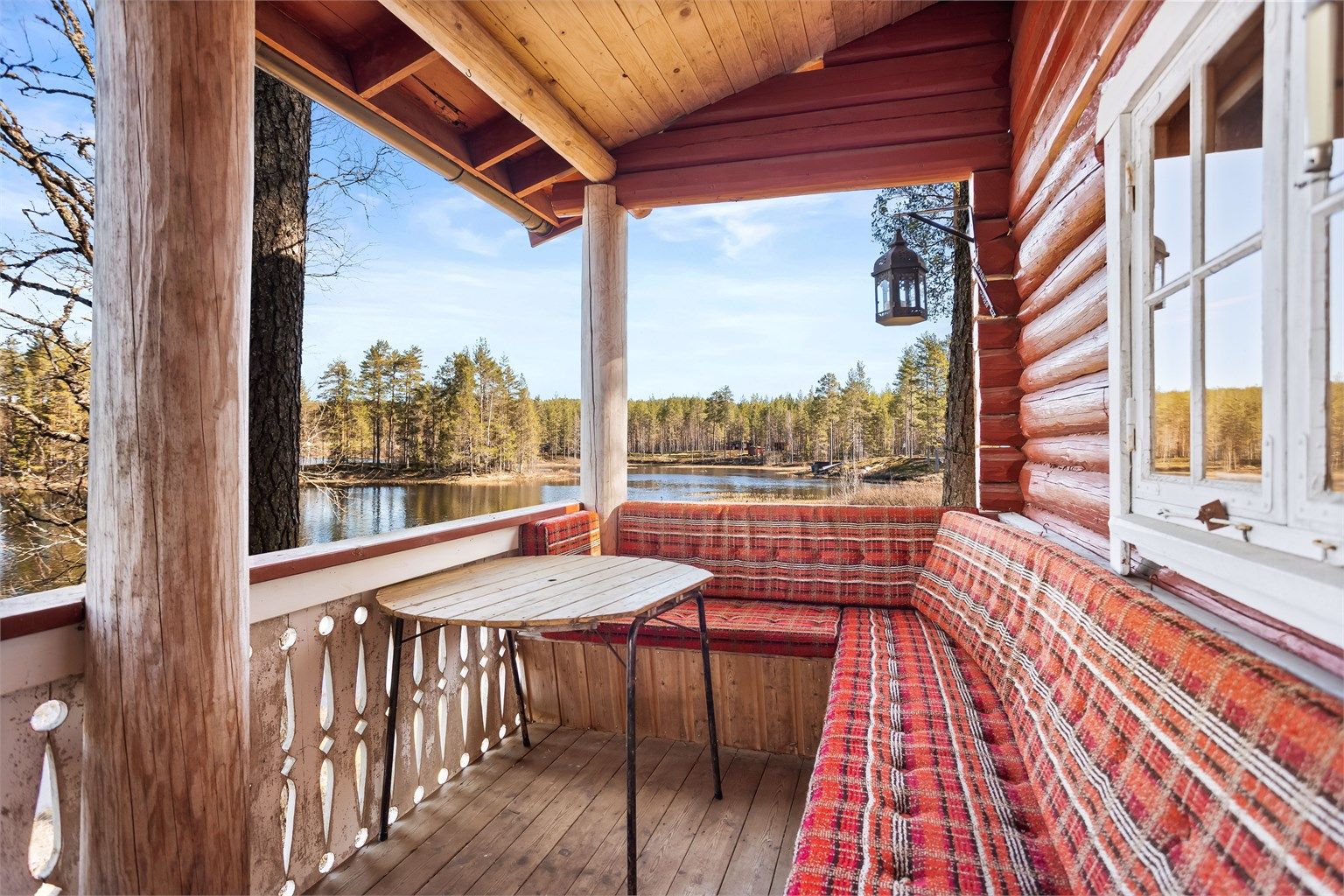 Den takoverbygde terrassen gir en lun uteplass med utsikt over skog og vann.
Foto: [Fotograf eller fotofirma]