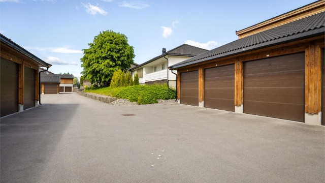 En parkeringsplass i garasjerekke merket med nr. 22. Plassen har montert elbillader.