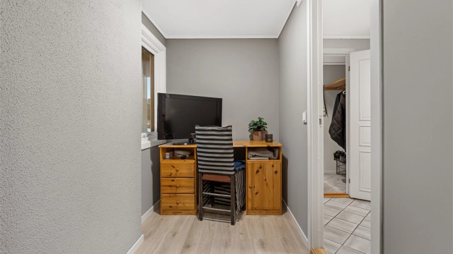 Soverom med nøytrale farger og god plass til seng / oppbevaring.