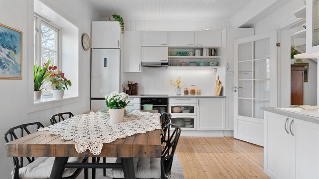 Kjøkkenet er lyst og trivelig, med god plass til et stort spisebord.