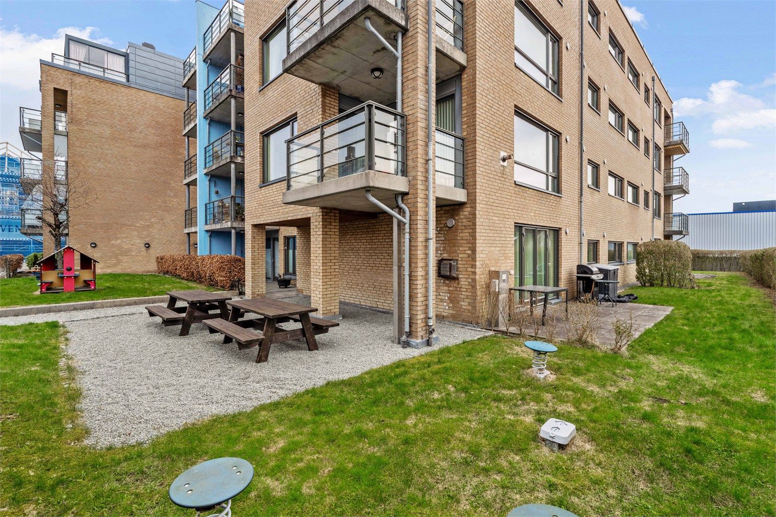 Hyggelig felles hage i bakgården med sittegrupper tilgjengelig for beboerne.