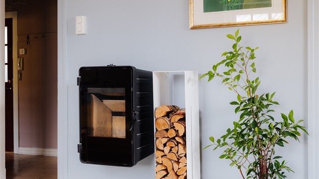 Vedfyring i peisovn med glassdør.