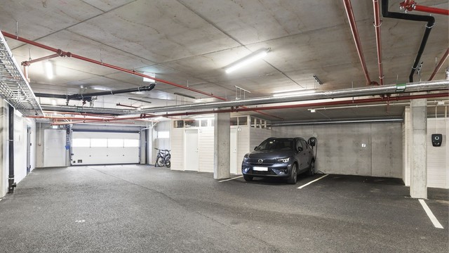Fast, romslig garasjeplass med tilrettelagt ladepunkt og tilhørende bod.