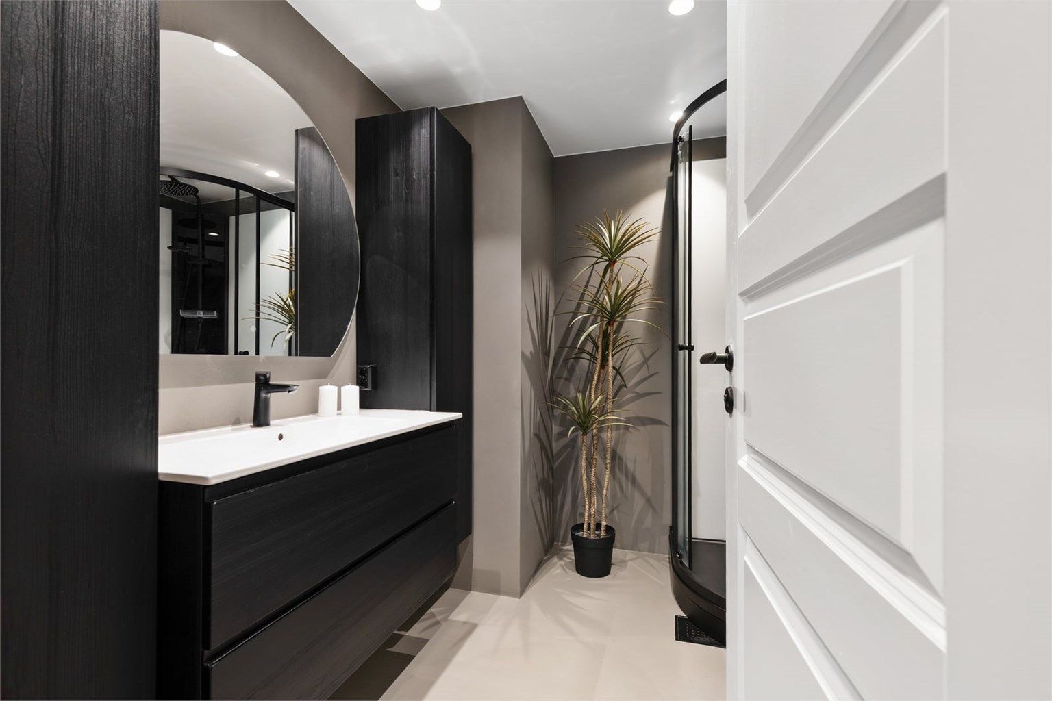 Badet er modernisert i 2023 med delikate overflater i mikrosement og innfelte downlights.