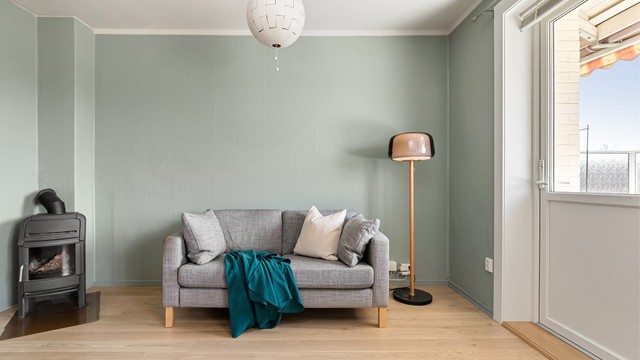 Stuen har en god planløsning med plass til både en sofa med tilhørende mediemøblement og spisebord. Persienner er montert på stuevinduene