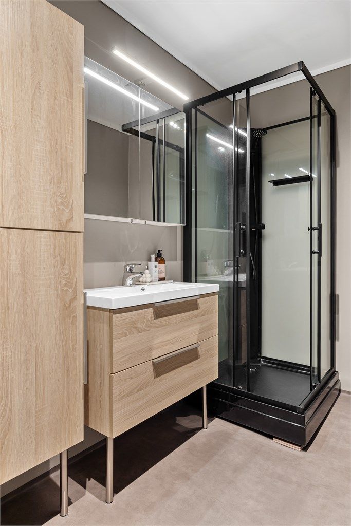 Innredet med gulvstående servantinnredning og ovenpåliggende servant. Speilskap med overlys. Oppbevaring i gulvstående høyskap.