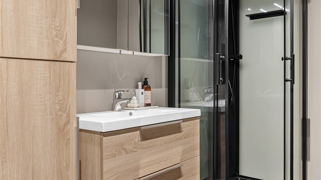 Innredet med gulvstående servantinnredning og ovenpåliggende servant. Speilskap med overlys. Oppbevaring i gulvstående høyskap.