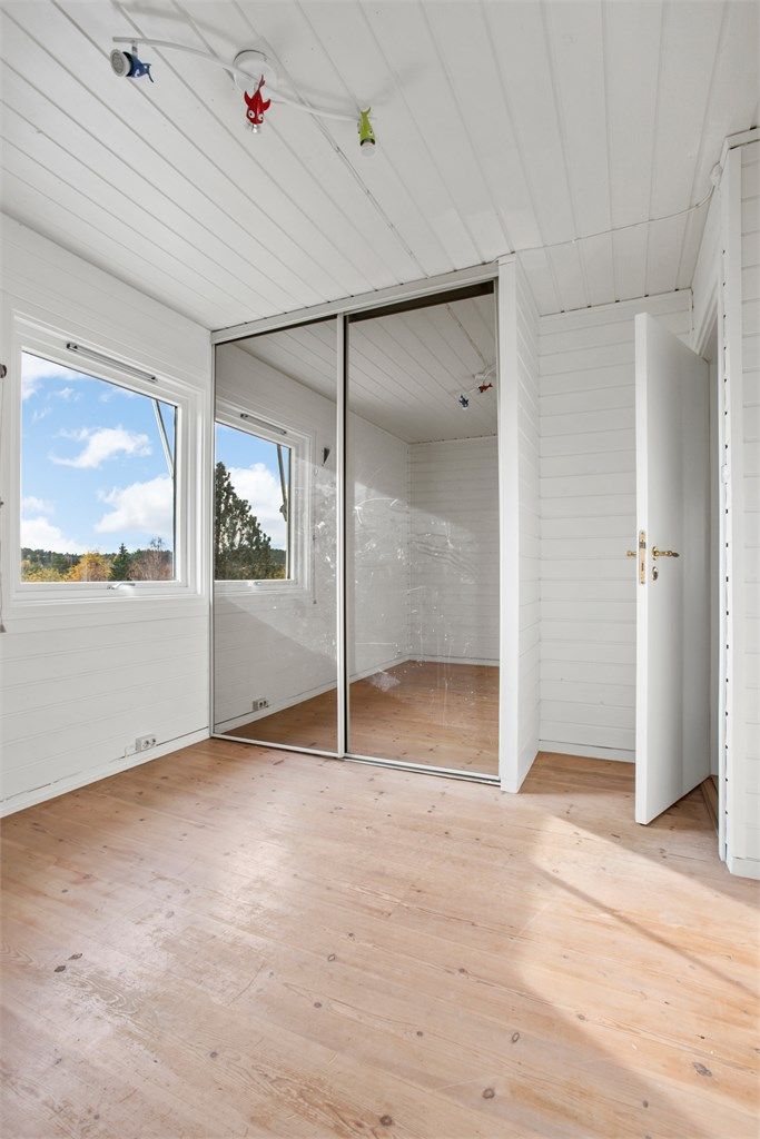 Soverom utstyrt med skyvedørsgarderobe med speildører.
