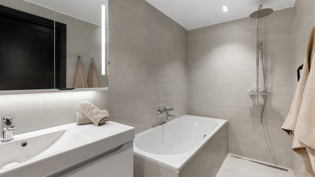 Moderne og flislagt baderom fra 2019 med gulvvarme, LED downlights i himling og regnfallsdusj