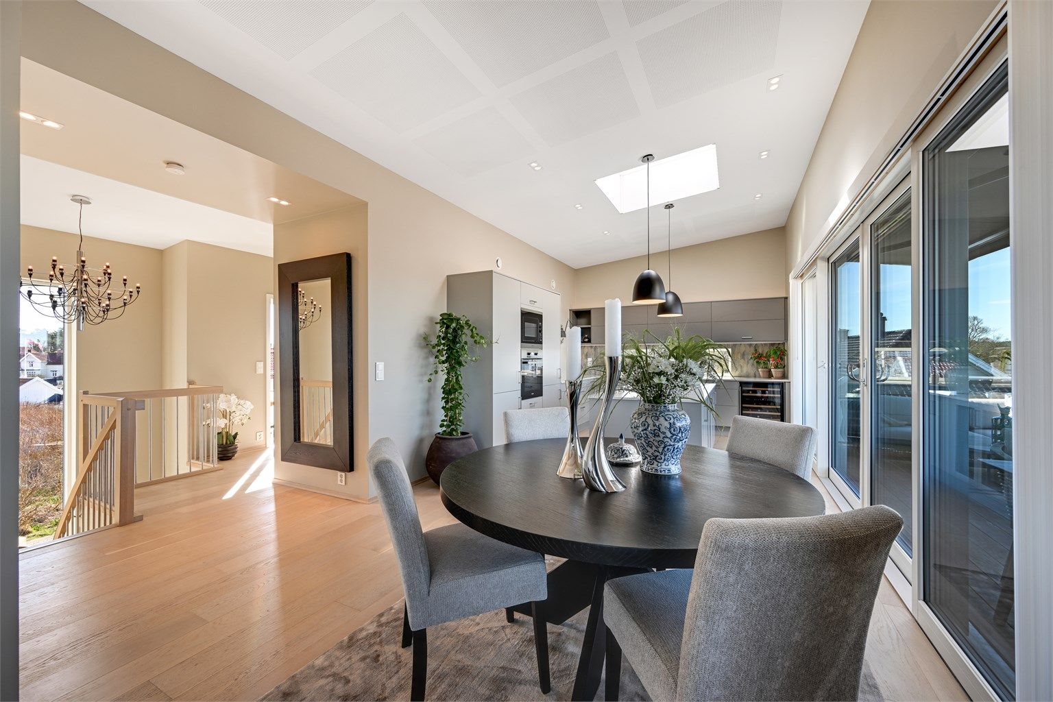 Spiseplassen er sentralt plassert mellom kjøkkenet og trappegangen, med skyvedører ut til balkongen.