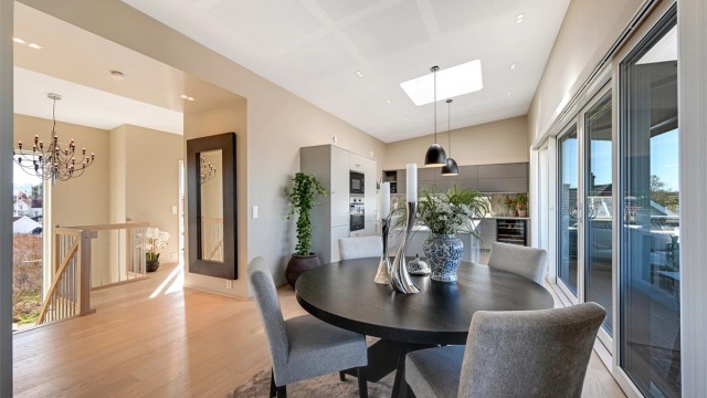 Spiseplassen er sentralt plassert mellom kjøkkenet og trappegangen, med skyvedører ut til balkongen.