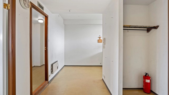 Romslig entré med plass til oppbevaring av yttertøy og sko i en praktisk nisje.