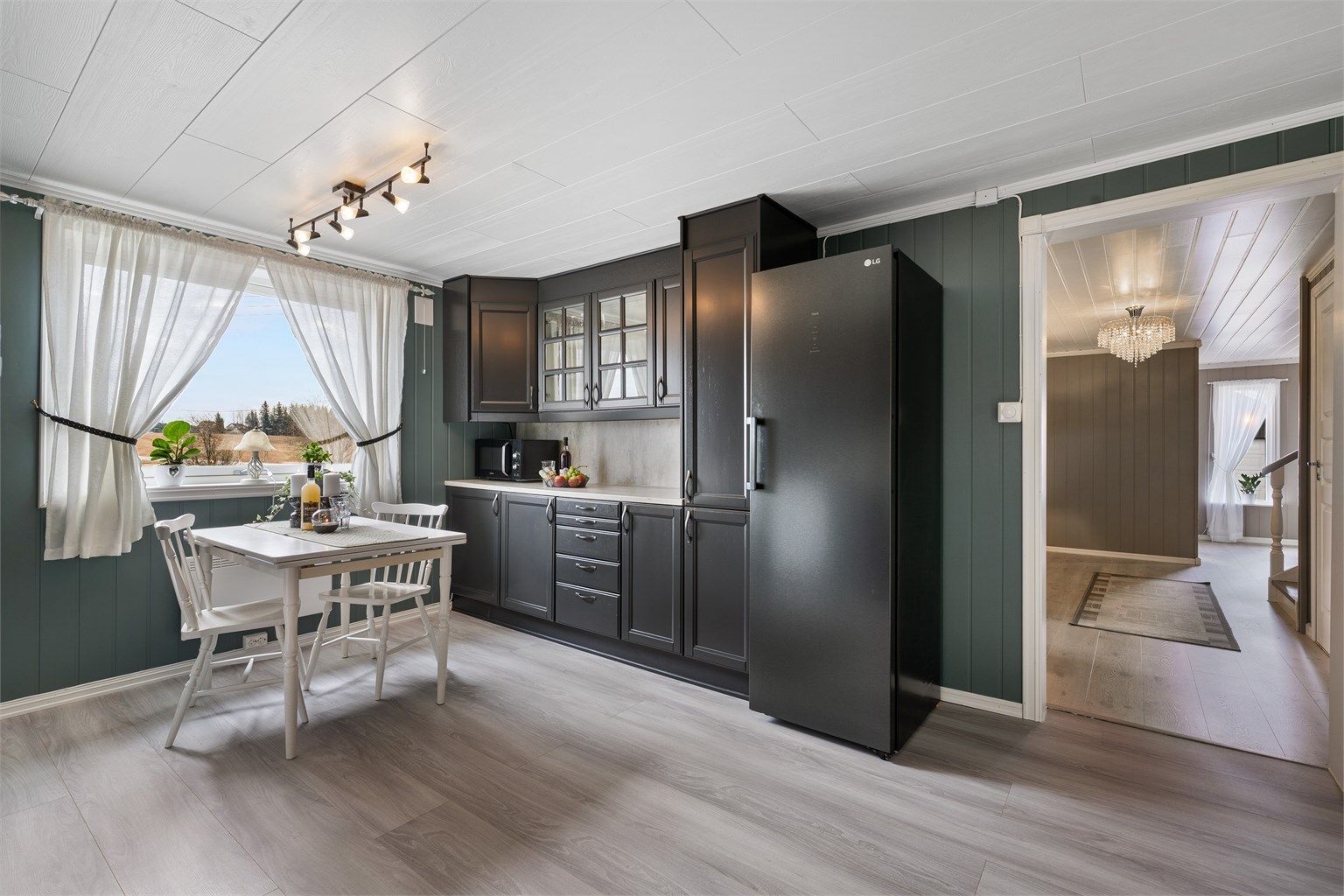 Praktiske doble stikkontakter under overskap. Kjøkkenet er utstyrt med frittstående komfyr plassert i nisje, innebygget oppvaskmaskin og frittstående kjøleskap.