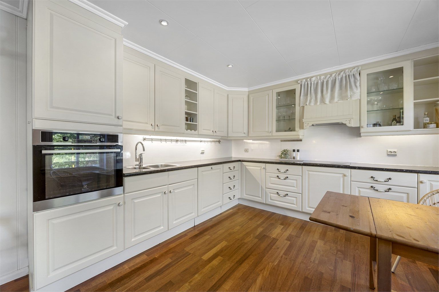 Innbydende stilrent kjøkken med integrerte hvitevarer og god skapplass