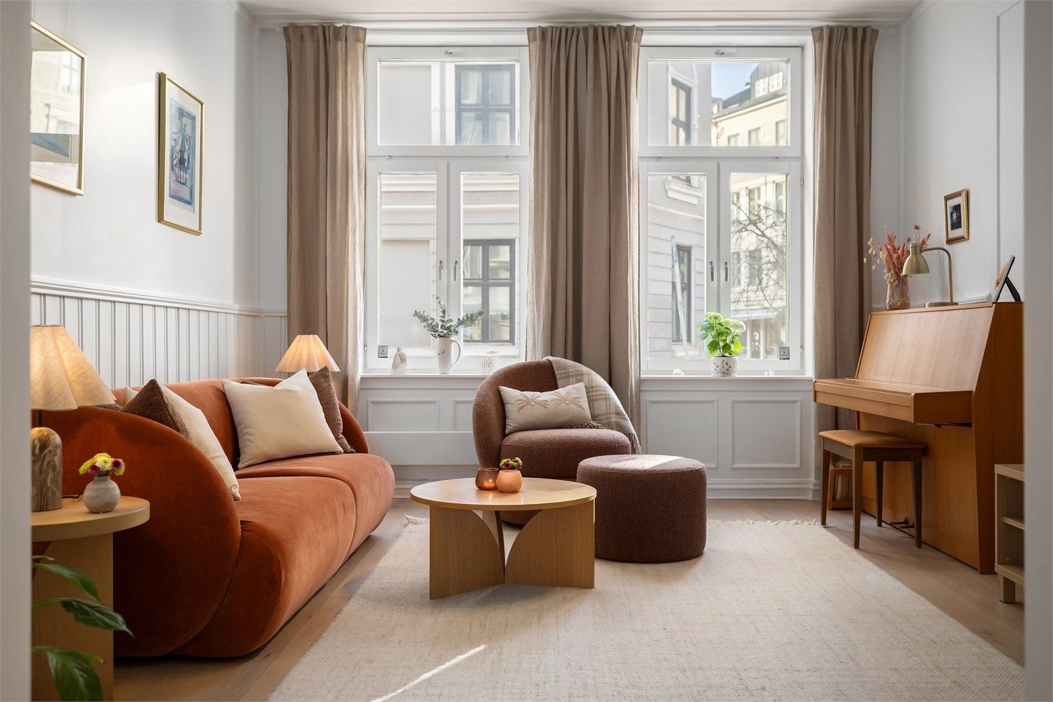 Leiligheten har store, klassiske vinduer som strekker seg helt opp til taket, og gir mye naturlig lys i alle rom