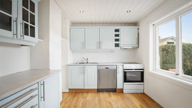 Kjøkkenet har en klassisk innredning med profilerte fronter og benkeplater i heltre