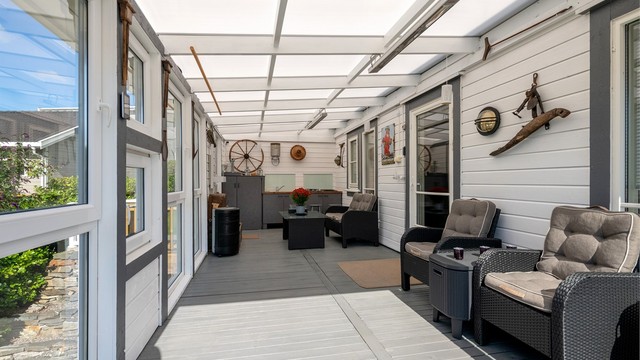 Innglasset utestue tilknyttet stuen med god plass til sittegrupper og helårsbruk.