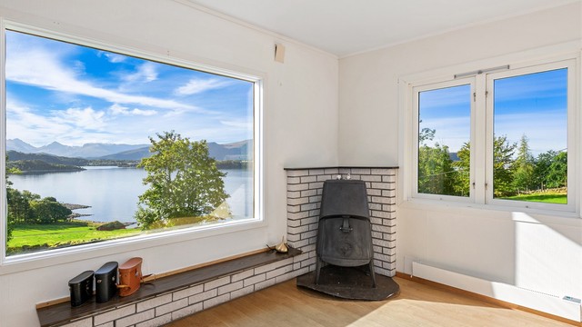 Stuen i påbygget har peisovn og utsikt mot Ellingsøyfjorden.