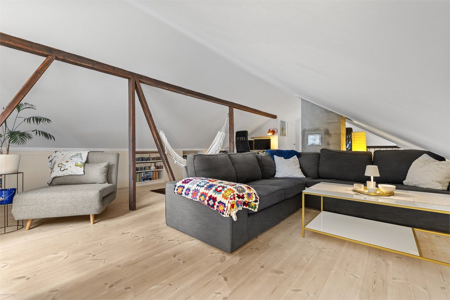 Loftstuen har tregulv, synlige trebjelker og god plass til en stor sittegruppe.