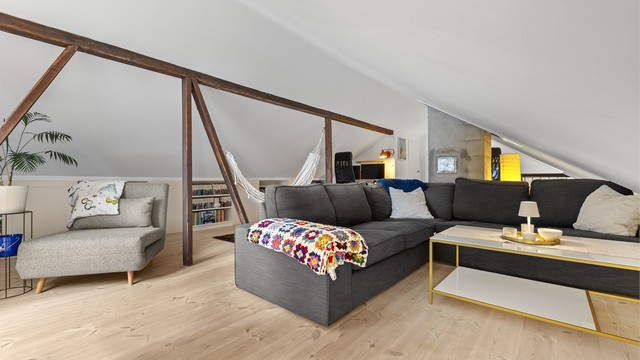 Loftstuen har tregulv, synlige trebjelker og god plass til en stor sittegruppe.