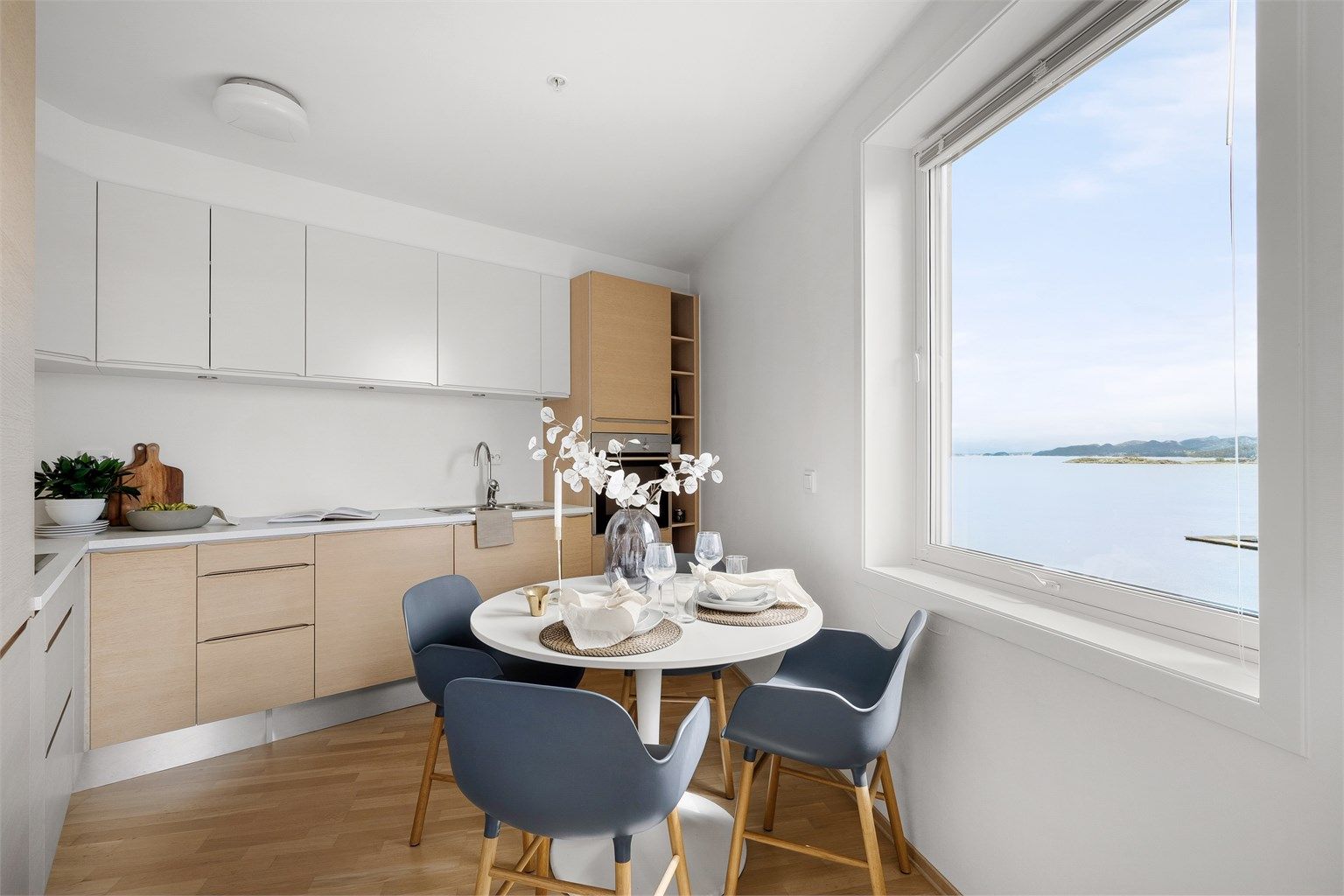 Kjøkkenet er i moderne og fint design med eikefronter og lys benkeplate. Ved kjøkkenet er det god plass til spisebord og man kan nyte flott sjøutsikt. 