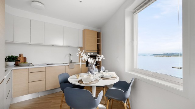 Kjøkkenet er i moderne og fint design med eikefronter og lys benkeplate. Ved kjøkkenet er det god plass til spisebord og man kan nyte flott sjøutsikt.