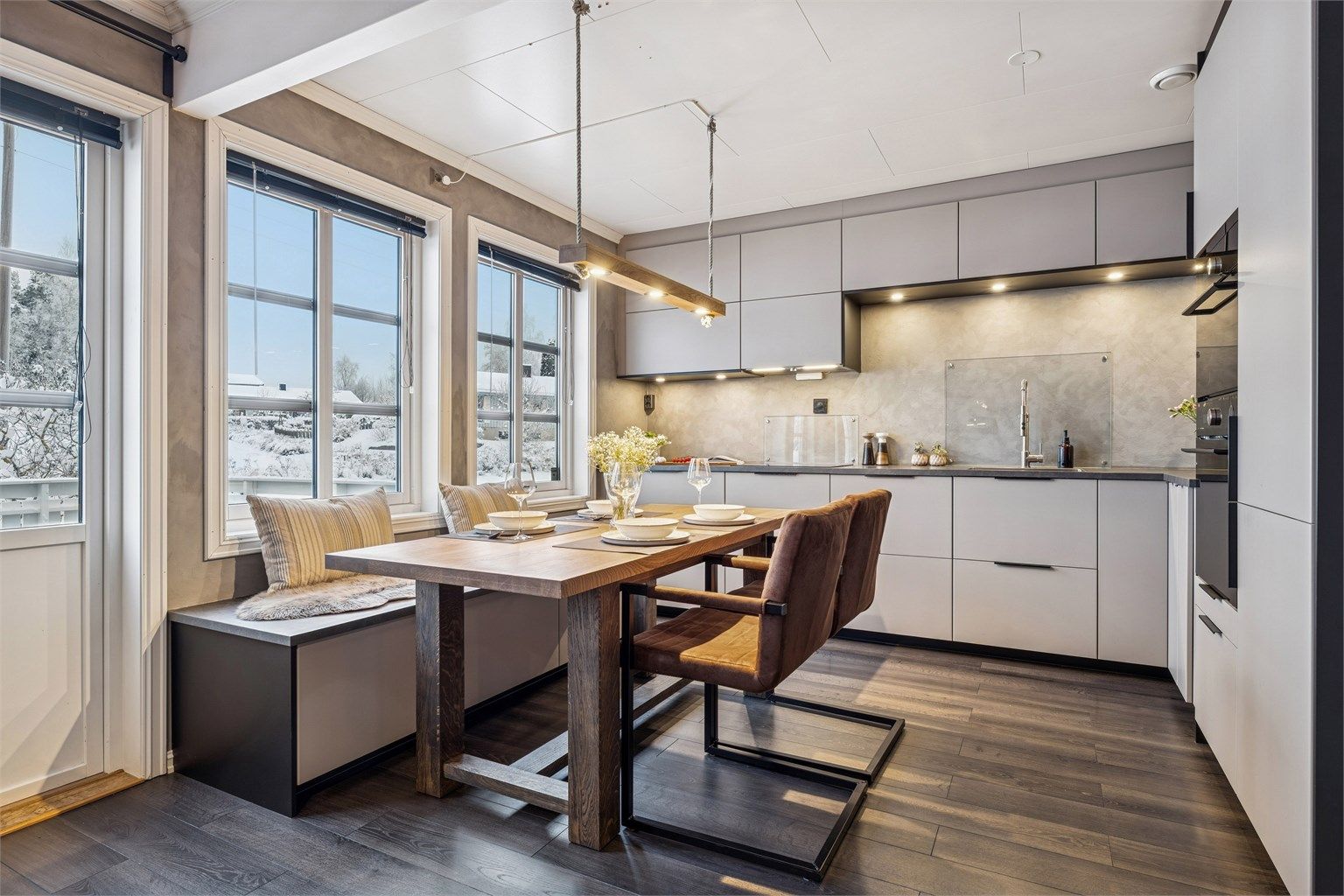 Kjøkkenet har smakfull innredning fra 2018 med glatte fronter, integrerte hvitevarer og god benkeplass. (Foto: EFKT v/Kristian Haug)