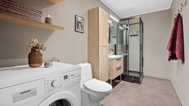 Bad med gulvbelegg og malte vegg- og himlingsflater. Opplegg for vaskemaskin.