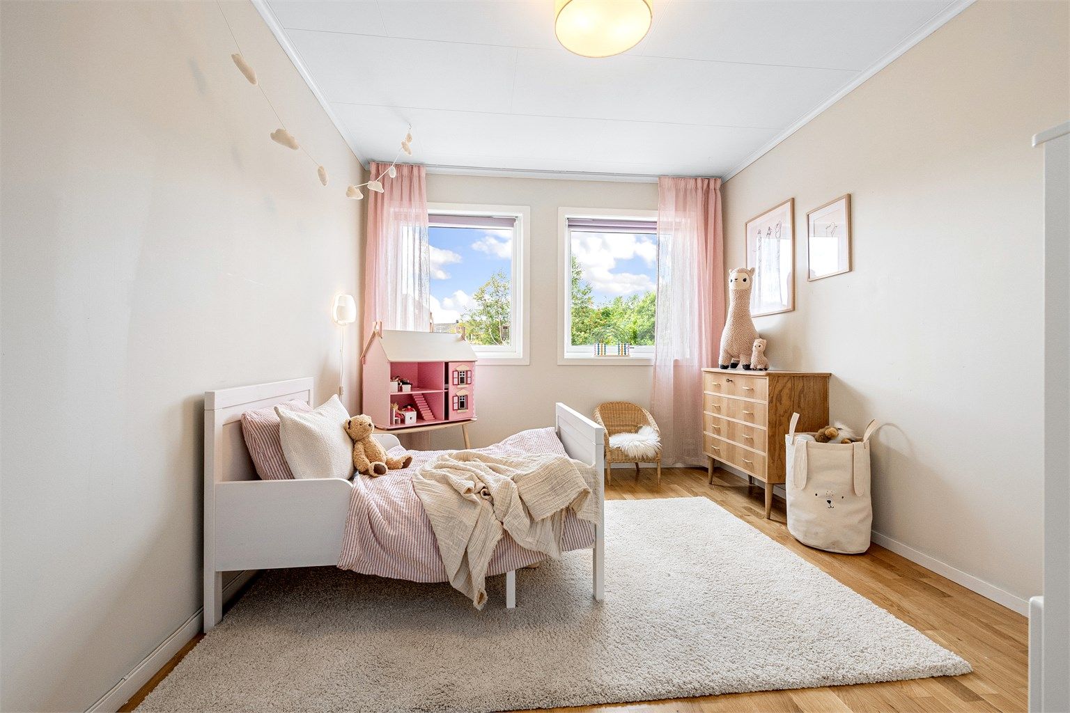 Lyst og trivelig soverom i underetasjen, med plass til seng og lekeareal.