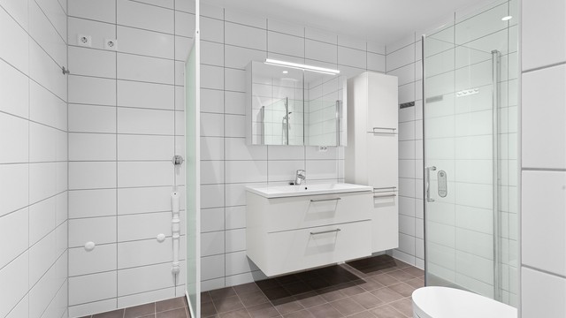Badet har dusjhjørne med innfellbare glassdører, dusjtoalett og opplegg for vaskemaskin.