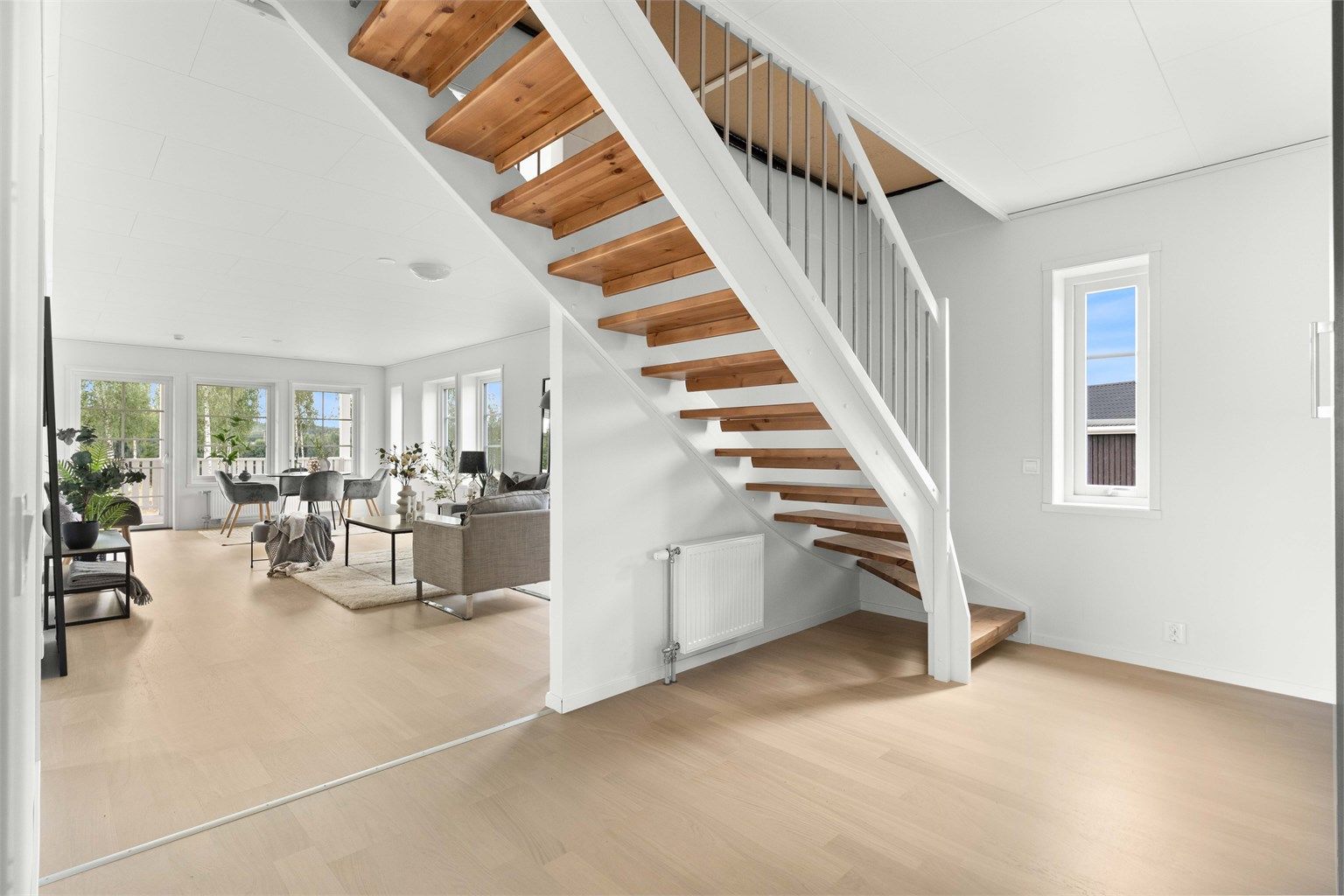Lys og romslig entre med flott trappeløsning - et godt førsteinntrykk som leder deg videre til stue og andre etasje.