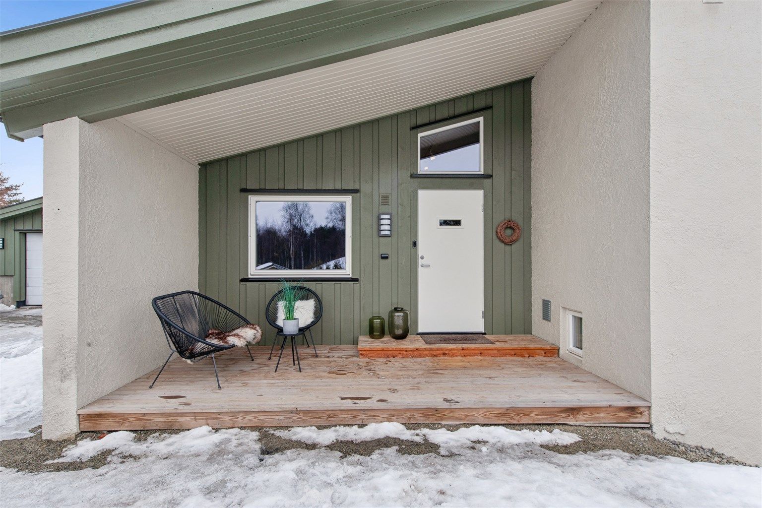 Koselig inngangsparti med samme arkitektoniske preg som boligen.