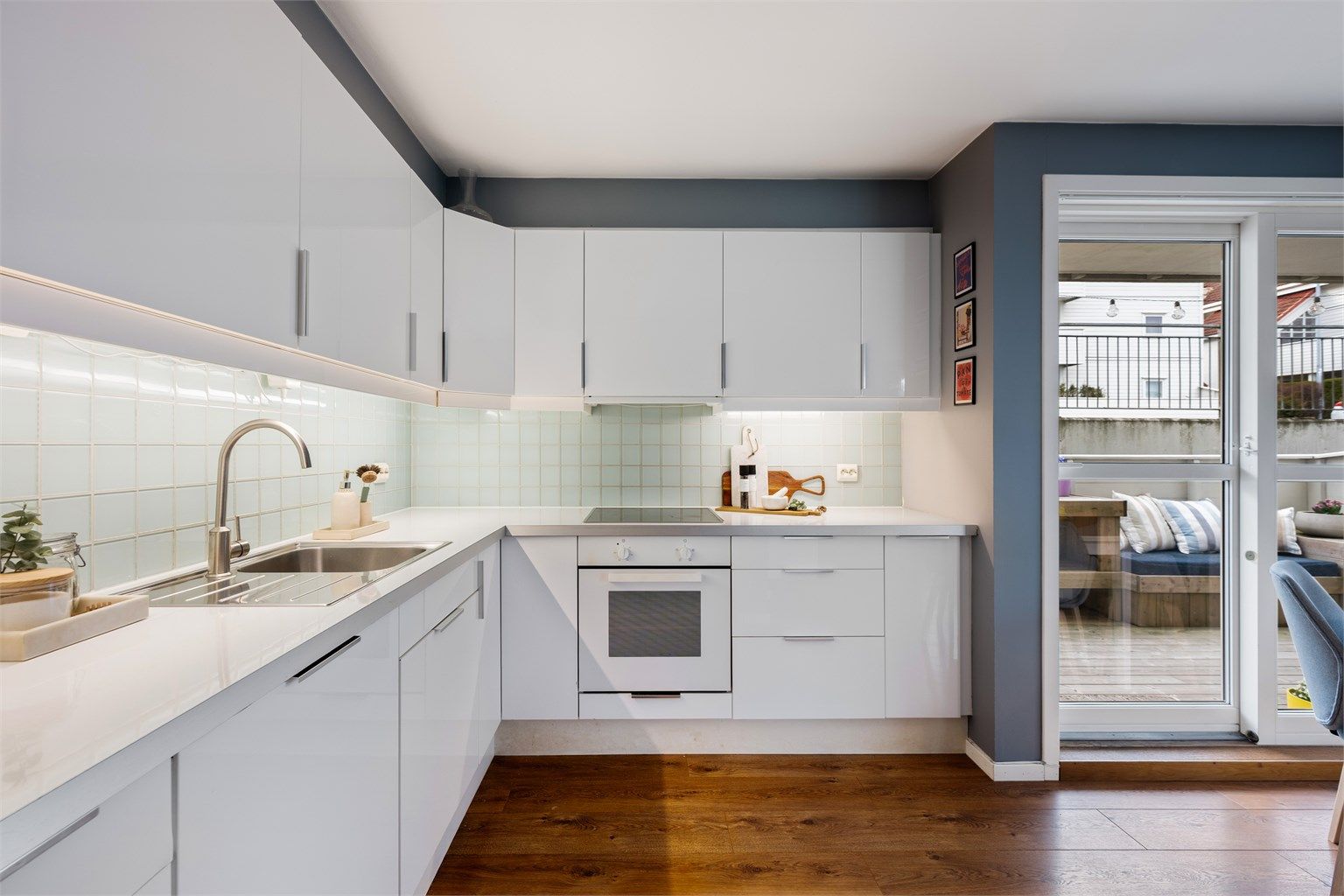 Godt med benkeplass og oppbevaring i skuffer og skap. Fliser mellom benk og overskap. 